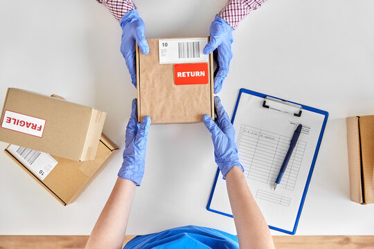 health protection, delivery and mail service concept - customer making return of parcel or purchase and worker in protective gloves receiving box