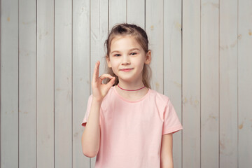 Very well. Happy little girl showing okay OK sign, agree, like and praise something good, make...