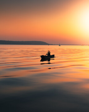 silhouette of a person in a boat at sunset
