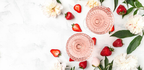Rose wine in glasses with Peony Flowers and sweet fresh strawberries on white background, Summer drink for party, wine shop or wine tasting concept