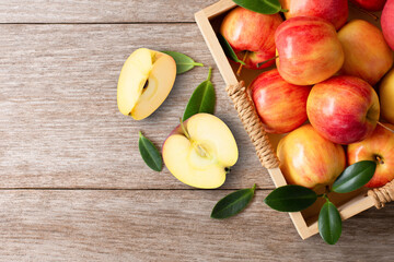 Red apples with green leaf and half slice on wooden table background. 