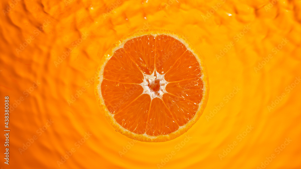 Poster fresh orange slice falling into splashing water splashing, top view.