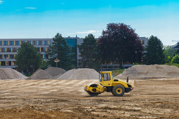 A construction roller spreads out the ground at a construction site.