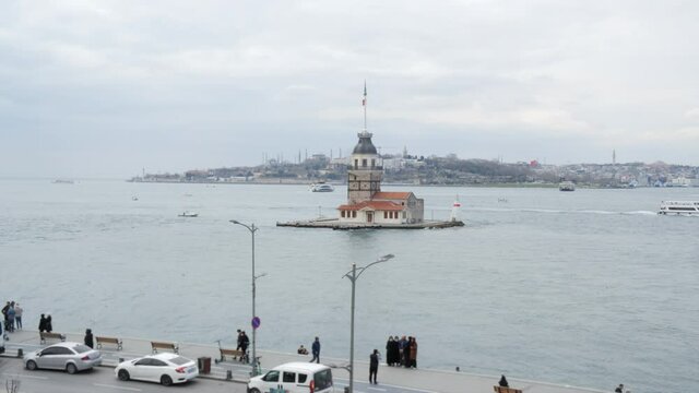 Maiden Tower in Bosporus, modern Istanbul city, Turkey. Tourist people walking and photographing landscape from city embankment to Kiz Kulesi Tower