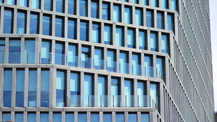 Obraz premium Abstract image of looking up at modern glass and concrete building. Architectural exterior detail of office building. Industrial art and detail. Sunrise.