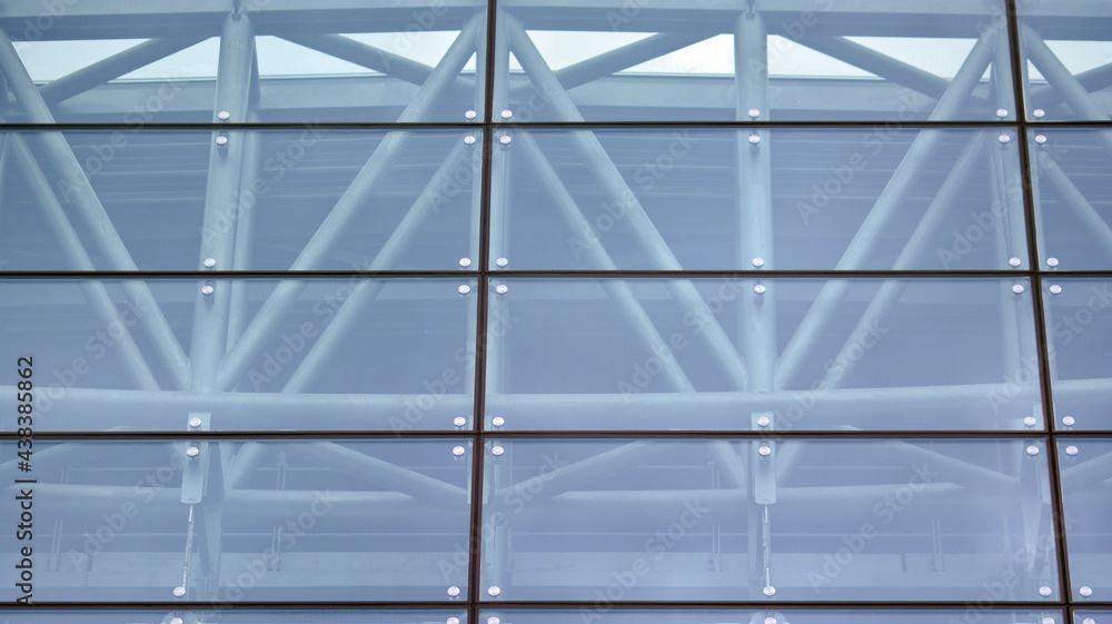 Wall mural abstract closeup of the glass-clad facade of a modern building covered in reflective plate glass. ar