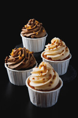 Chocolate cupcake, muffins in a paper cup with cream and sprinkles 