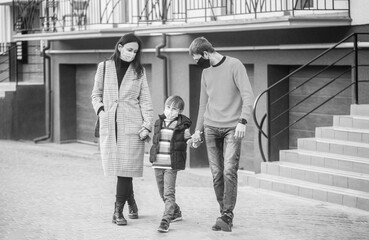 Young family wearing protection face mask outdoors. Prevention coronavirus. Coronavirus quarantine. Family going for a walk. Parents and kid wearing a surgical mask. Air pollution concept
