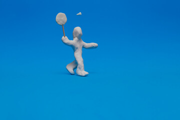 A white modeling clay dummy practicing badminton