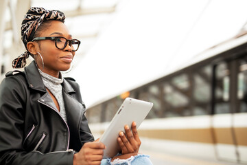 Happy young woman waiting for the train. African woman waiting for a subway train...