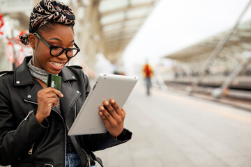 Happy young woman waiting for the train. African woman waiting for a subway train...