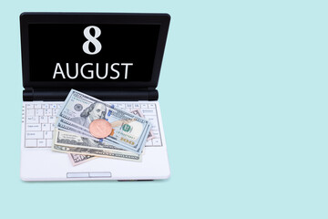 Laptop with the date of 8 august and cryptocurrency Bitcoin, dollars on a blue background. Buy or sell cryptocurrency. Stock market concept.