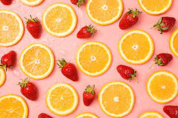 Top view photo of strawberries orange slices and water drops on isolated pastel pink background