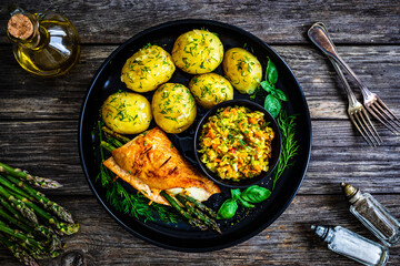 Stuffed turkey breast with mozzarella and asparagus,    boiled potatoes and fresh vegetable salad on wooden background
