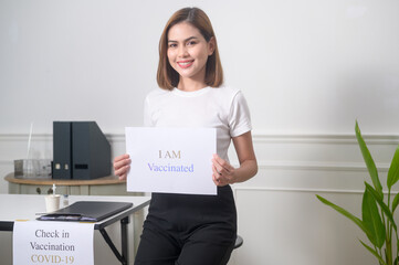 Young woman holding I am vaccinated sign, covid-19 vaccination and health care concept