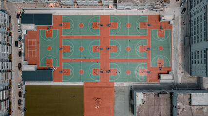 Top down aerial view of residential area, school, university with many basketball courts between buildings. Geometry lines in architecture, modern city development care about sports and healthy people