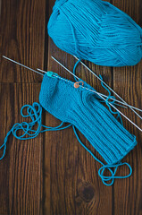 Knitting a warm sock from blue wool yarn