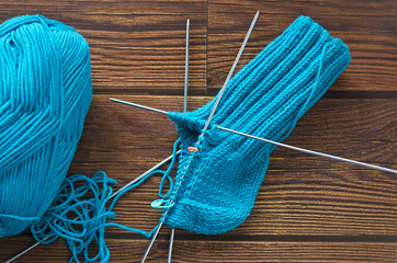 Knitting a warm sock from blue wool yarn