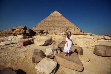 Beautiful woman near the ancient pyramids of Egypt