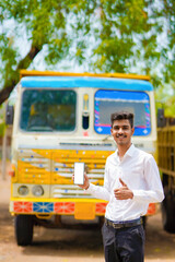 Young indian businessman with his freight forward lorry or truck