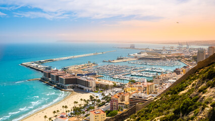 Alicante, beach and port with luxury yachts and sailboats from above at sunset. View of beautiful touristic town in Costa Blanca region on Mediterranean sea coast, Spain