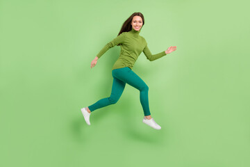 Fototapeta na wymiar Full length photo of attractive young woman jump up good mood run sale travel dream isolated on green color background