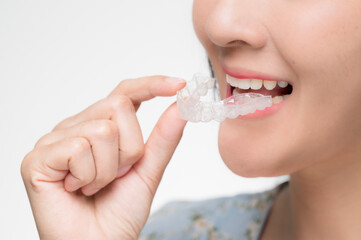Asian woman wearing orthodontic silicone trainer. Mobile orthodontic appliance for dental...