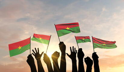 Silhouette of arms raised waving a Burkina Faso flag with pride. 3D Rendering - obrazy, fototapety, plakaty