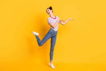 Photo of funny funky young lady dressed striped outfit dancing isolated yellow color background