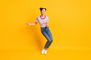 Fototapeta na wymiar Photo of charming pretty young girl dressed striped t-shirt looking empty space dancing isolated yellow color background