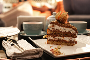 tea ceremony in a cafe. man pours tea from a teapot into a cup. desserts cakes on the table with tea
