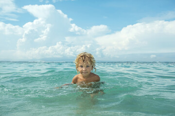 Curly boy in the sea  have a fun