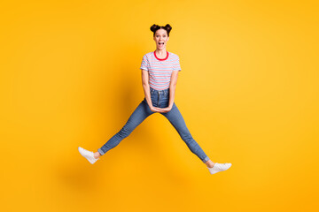 Fototapeta na wymiar Full length photo of sweet shiny young lady wear striped t-shirt jumping high legs sides isolated yellow color background