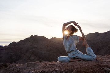 Woman practicing yoga in the mountains in the desert