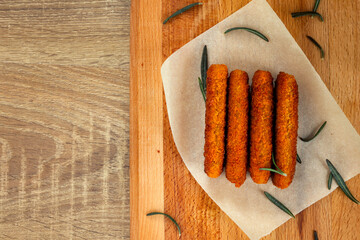 4 fish fingers with rosemary leaves on parchment paper