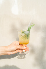 Glass of summer non alcoholic orange lemonade in hand