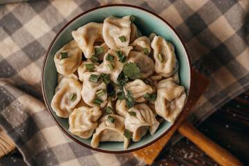 Boiled dumplings in a deep bowl, sprinkled with fresh green onions