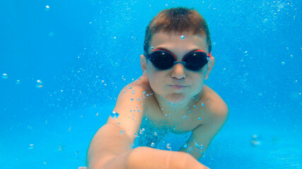 Naklejka premium Portrait of Underwater Boy Fun in the Swimming Pool with Goggles. Summer Vacation Fun.