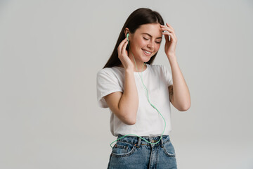 Young brunette woman listening music with earphones