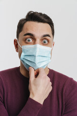 Young brunette shocked man in face mask looking at camera
