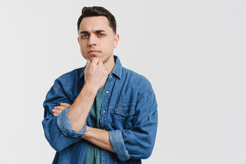 Young brunette white man frowning and looking at camera