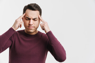 Fototapeta premium Young brunette man with headache rubbing his temples