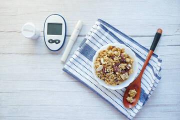  diabetic measurement tools and breakfast cereal in a bowl on table 