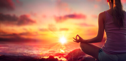 Yoga At Sunset - Woman In Meditation - Focus On Foreground And Blurred Background