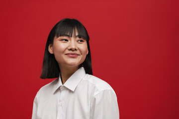 Young asian brunette woman smiling and looking aside