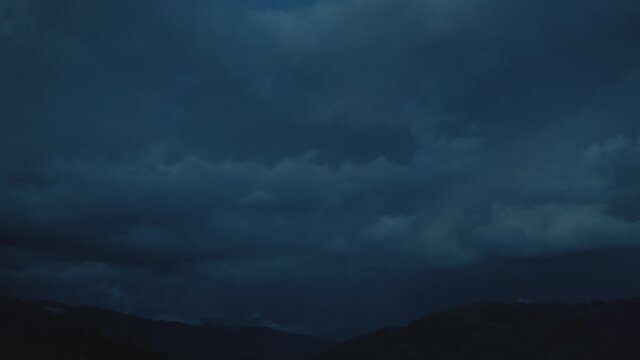 Lightning sparkles in the dark blue sky. Dramatic nature landscape. Explore beautiful world. Cinematic shot