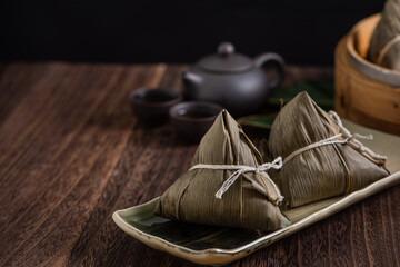 Zongzi. Rice dumpling for Dragon Boat Festival on dark wooden table background.