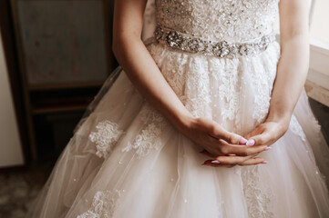 Obraz na płótnie Canvas Bride hands with beautiful manicure on wedding dress.