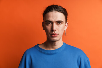 Obraz premium Young white man with earring posing and looking at camera
