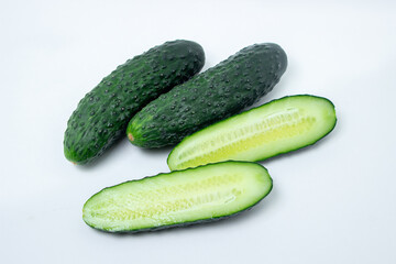 Cucumbers on a white background. The cucumber is cut lengthwise. Fresh ripe cucumbers.